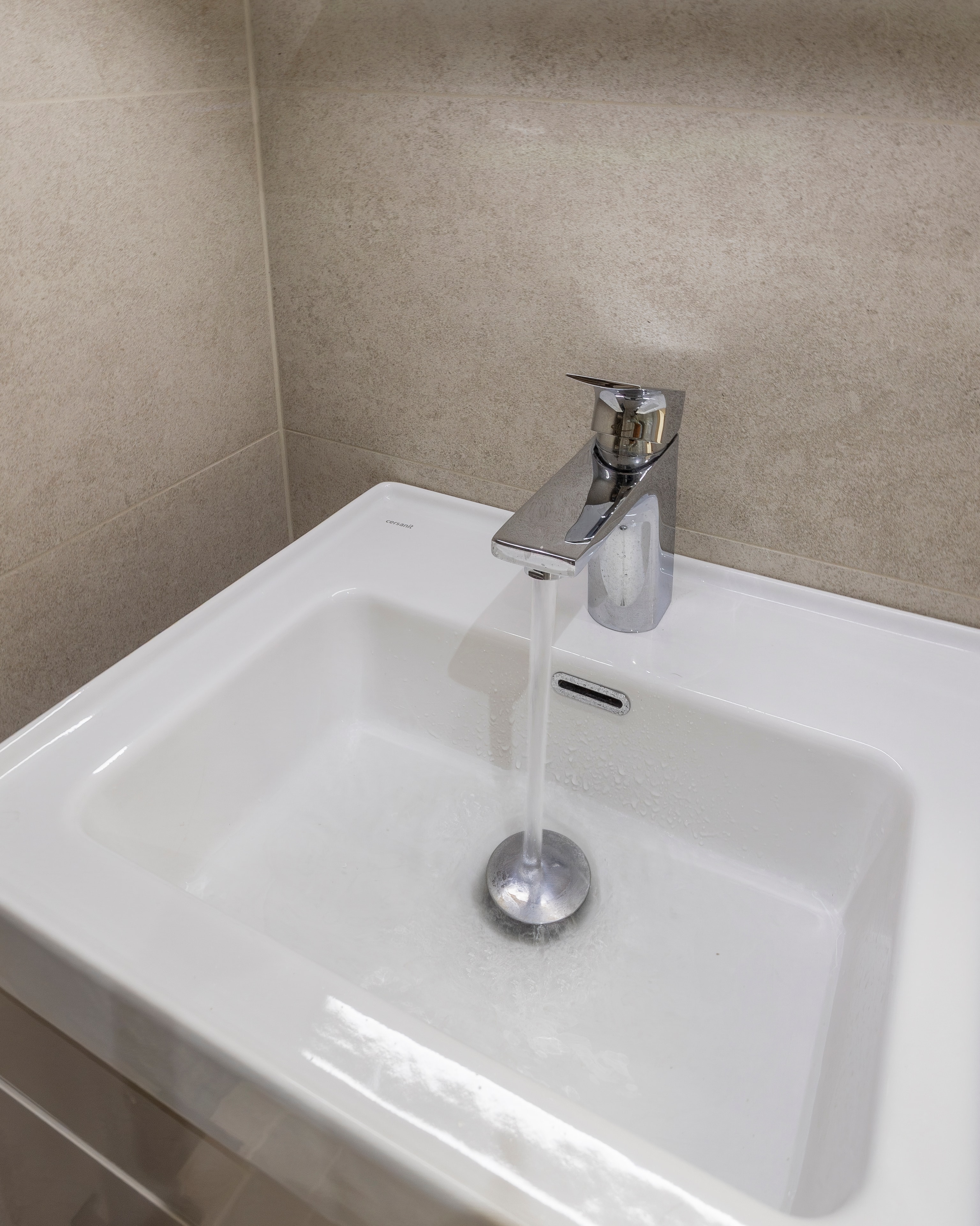 Beige basin running tap