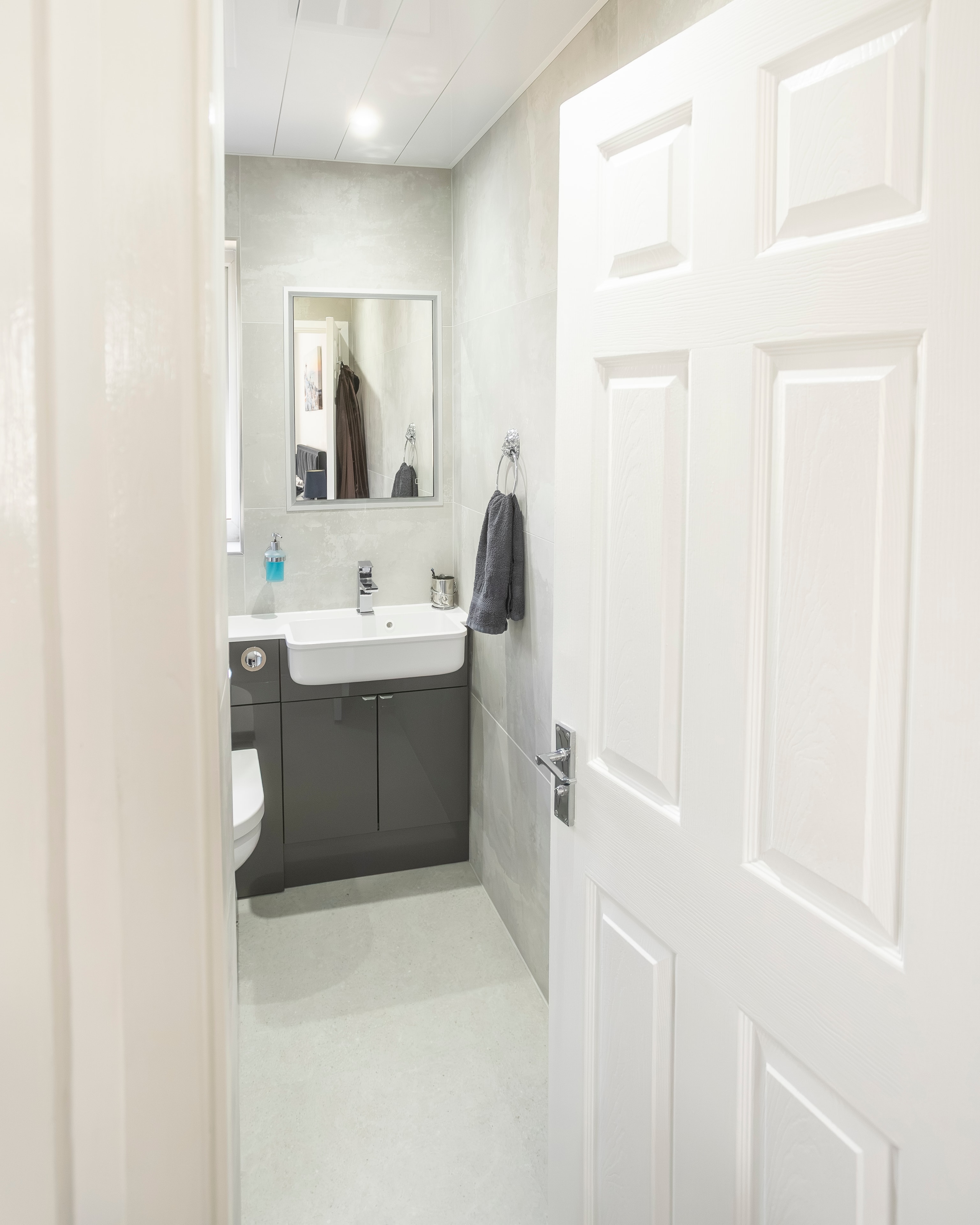 Grey gloss bathroom renovation — view through doorway