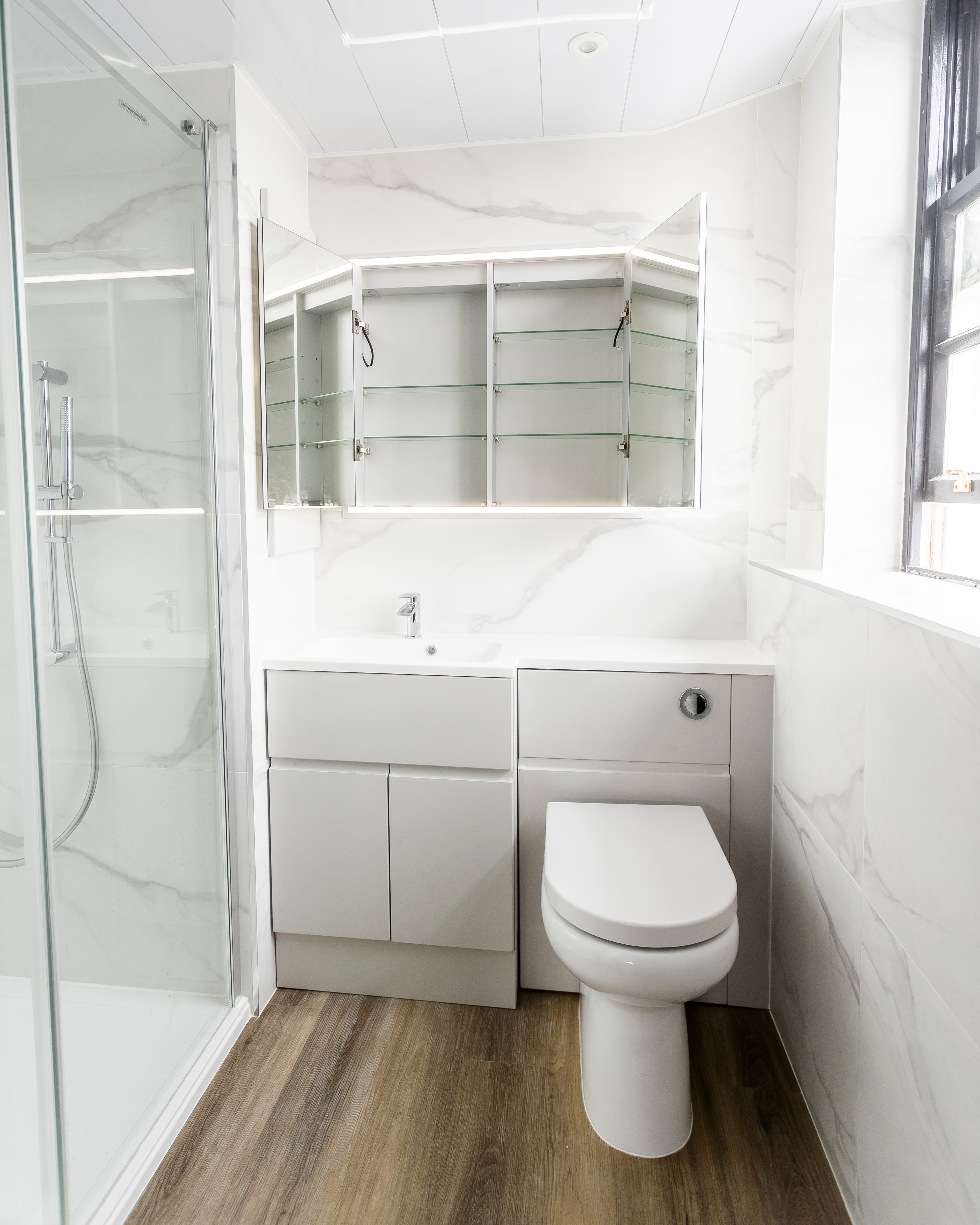 Full bathroom renovation with grey vanity and marble tiles